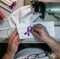 Person sewing a purple ribbon on a facemask in the workshop - COVID-19 awareness