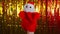 Person showing Santa Claus toy against golden Christmas tinsel. Crop unrecognizable person with plush hand Santa Claus