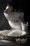 Person sifting flour into ceramic bowl. Dough preparation process. Milk, eggs, wooden table.