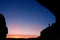 Person silhouetted at North Window Arch at sunrise, Arches National Park, Utah, USA