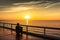 person, sitting on deck, enjoying peaceful view of the sunset