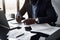 person, sitting at desk, checking and organizing documents for virtual meeting