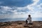 A person sitting on rocky mountain looking out at scenic natural view