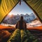 A person sitting in a tent looking out at the mountains. Generative AI image.