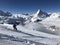 Person skier skiing in front of the Matterhorn Zermatt snowy mountains blue sky sun