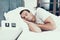 Person Sleeps Near Alarm in Bed With White Linens