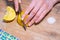 Person slices the lemon, next to the salt and kitchen towel. Cooking vegan salad, top view