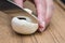 Person slicing a fresh agaricus mushroom