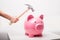 Person smashing piggy bank with hammer