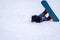 Person with snowboard on the snow. One Asian child is falling on the ground. Winter sport