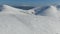 A person is speed gliding on slopes of the mountain, amazing view of snow covered mountains, aerial shot