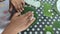 a person spreading batter in a banana leaf