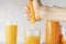 person squeeze fresh orange juice with a bare hand, healthy drink in a glasss