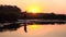 Person stand up paddle board on an inflatable raft into the sunset. Slow motion