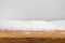 A person standing on a beach. Wood board heap snow