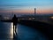 a person standing on a bridge at dusk