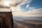 person, standing at the edge of a cliff, overlooking an epic view of a desert landscape