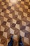 Person standing with sports shoes on parquet floor, top view