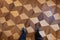 Person standing with sports shoes on parquet floor, top view