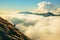 Person standing on the top of the mountain above the clouds. Generative AI