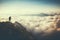 Person standing on the top of the mountain above the clouds. Generative AI