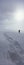 Person standing in winter landscape leaving behind trail of footprints