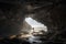 A person stands in a cave, bathed in sunlight, gazing at the ocean, creating a peaceful and contemplative scene, ai generative