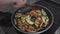 Person Stirring Chopped Mix Veggies Cook In A Pan Over Electric Burner. High Angle