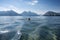 person, swimming in crystal-clear lake, with mountains visible in the background