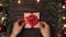 person takes a Christmas box from a wooden table.