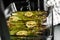 Person taking glass baking dish with cooked asparagus and lemon slices from oven