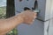Person taking parking check/ticket from a parking machine/vending machine. Hand close-up. Transportation. City infrastructure