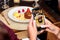 Person taking a shot of a chocolate dessert with a smartphone