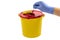 A person throwing away a syringe into a medical waste container