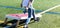 Person throwing a bean bag while playing cornhole on a turf field