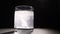 Person throwing vitamin mineral supplement effervescent tablet into glass of water. Studio shot on dark background