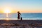 Person traveling Woman staying on Ocean Beach at Sunrise