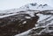 Person trekking on a footpath to the snow mountain. Trekker hiking in winter.