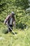 Person trimming the lawn with a weed eater