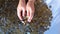 Person two hands rakes coins on table, pours spills from handful to surface