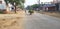 A person on two wheeler is over loaded with fodder and seems talking with a school going boy in India