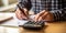 A person using a calculator and writing in a notebook, depicting personal budgeting , concept of Financial Planning