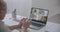 Person Using Video Conferencing technology in kitchen for video call with colleagues at home and in offices