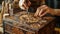 A person using a wood burning tool to create intricate designs on a wooden box.