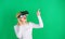 A person in virtual glasses flies in room space. Excited smiling businesswoman wearing virtual reality glasses. Woman