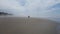 Person walking on beach with ocean and sand and waves in Newport, Oregon