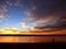 Person walking on a beach at sunrise