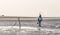 Person walking with camera and tripod on beach