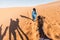 Person walking in front of a camel during a camel ride in a desert in Morocco