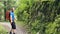 Person Walking on a Green Trail Surrounded by Trees